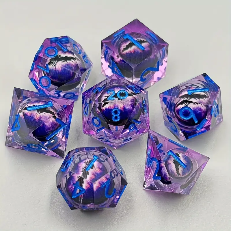 Set complet de 7 dés de JDR en résine transparente violette. Chaque dé renferme un œil de dragon aux tons violets et noirs, avec des chiffres bleu électrique.

