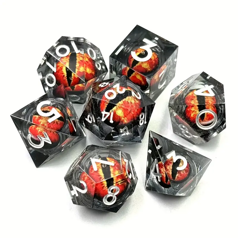 Set complet de 7 dés polyédriques pour JDR. Les dés sont transparents et renferment un œil de dragon rouge et orange au design réaliste, sur fond blanc.